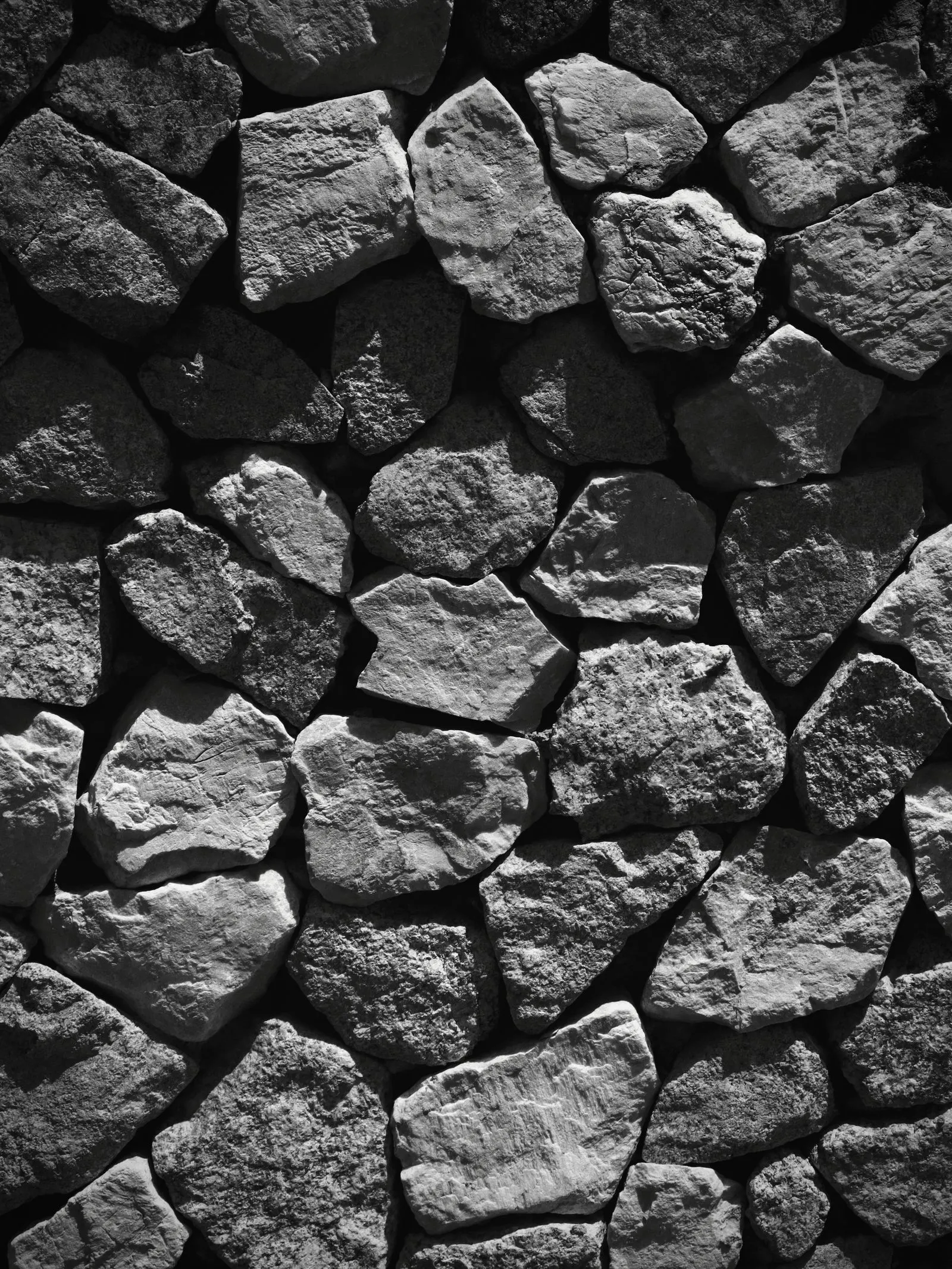 Black and white textured wall of natural stones